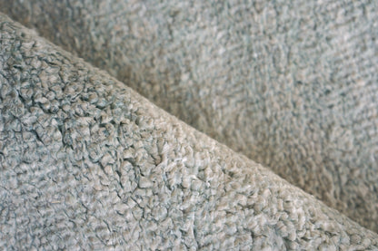 Close-up of light gray plush indoor hand-knotted rug with soft shag pile, 2' x 3'.