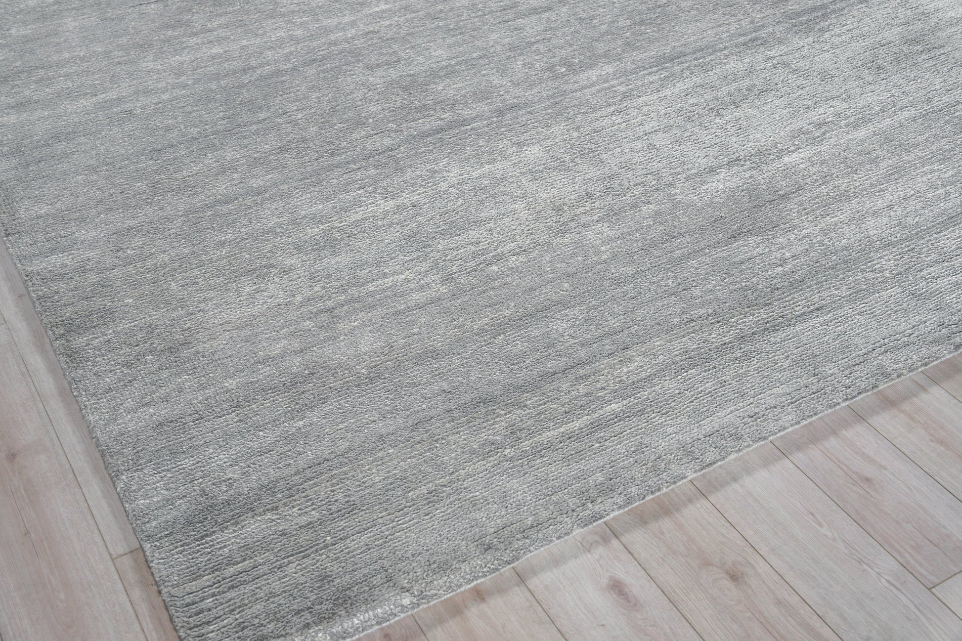 Rectangular gray textured rug with subtle heathered tones on light wood floor.