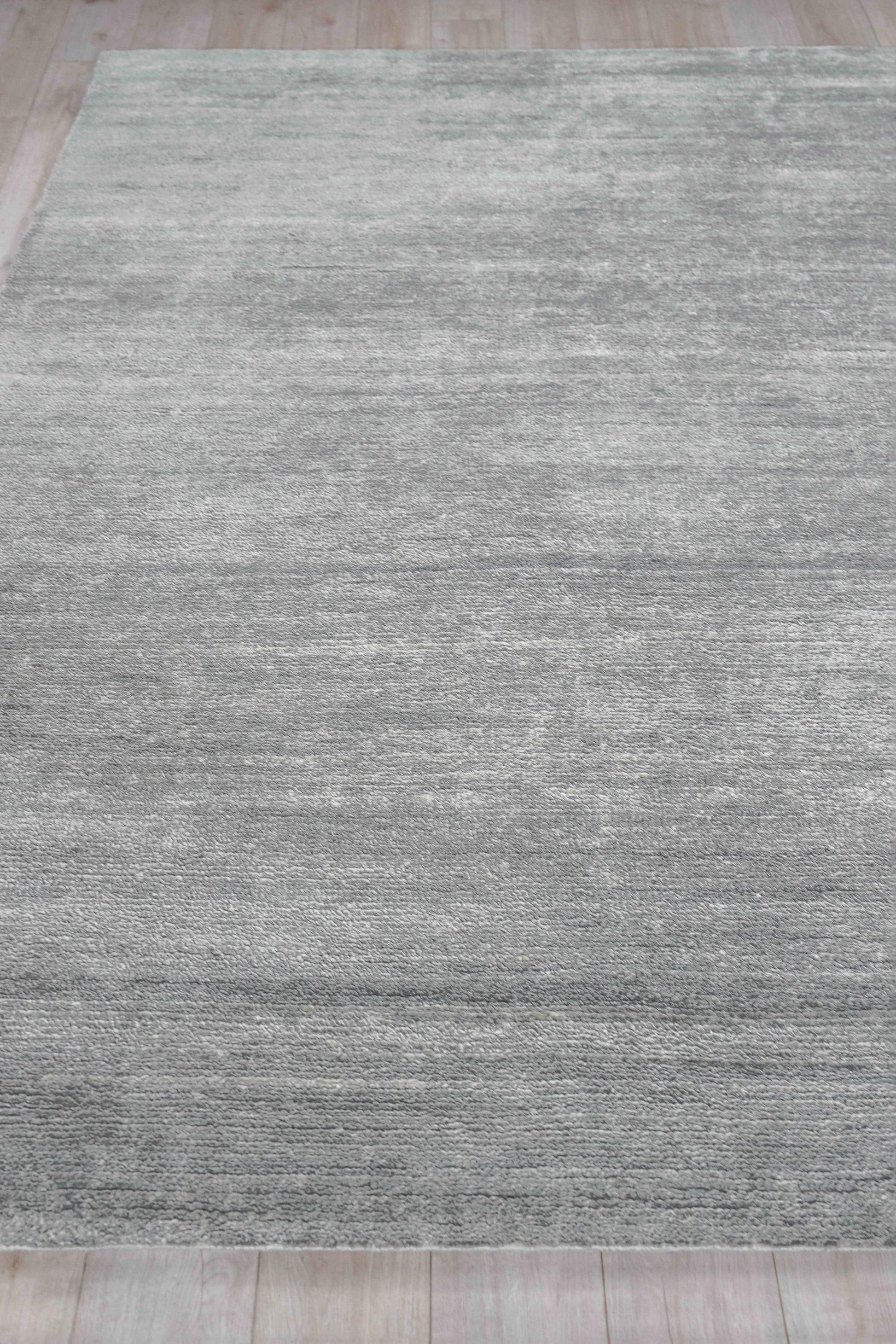 Gray textured hand-knotted indoor area rug with tonal variation on a light wood floor, 2' x 3'.