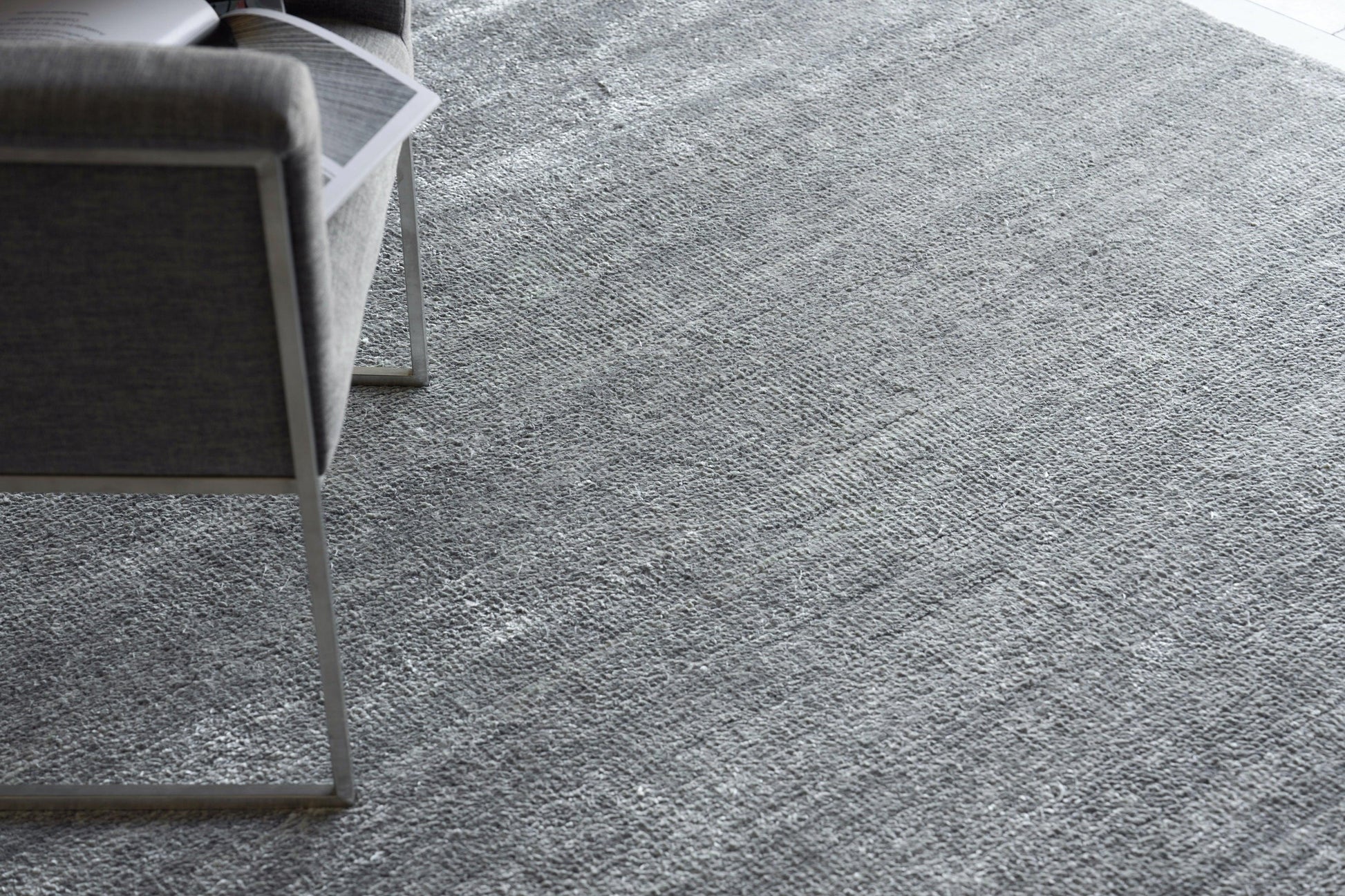 Gray plush indoor hand-knotted rug, 2' x 3', with a textured surface on the floor.