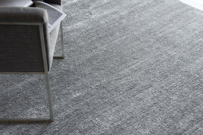 Gray plush indoor hand-knotted rug, 2' x 3', with a textured surface on the floor.
