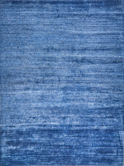 Blue distressed-texture rug with soft pile and varied indigo tones.