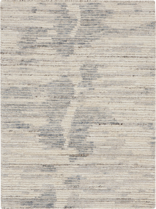 Beige and blue-gray abstract rug with subtle horizontal texture and cloud-like patches.