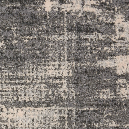 Grey and beige distressed area rug with an abstract, patchy geometric pattern and soft, plush texture.