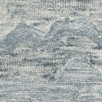 Blue-gray textured rug with an abstract mountain motif in ivory and dark blue, boucle woven look.