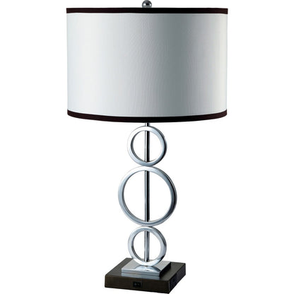 Modern chrome table lamp with stacked ring base, white drum shade with dark brown trim, on square base.
