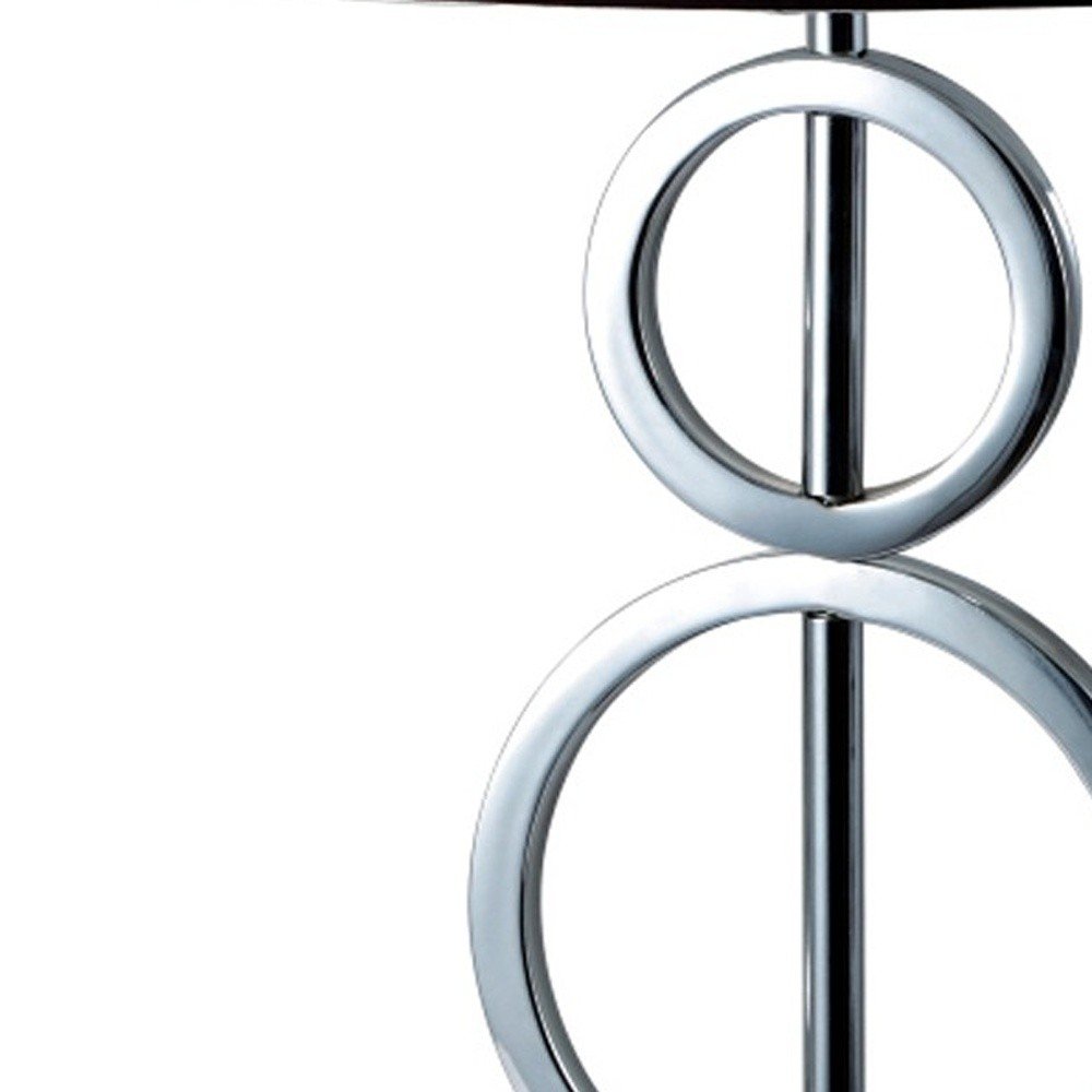 Silver metal table lamp with geometric stacked-ring design and a white and black trim classic drum shade.