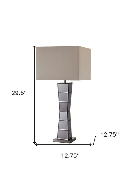 Black glass tower table lamp with a beige fabric shade; faceted base, 29.5" high, 12.75" wide.