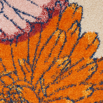 Close-up of a tufted orange floral rug with pink and blue accents; shaggy pile and abstract flower pattern.
