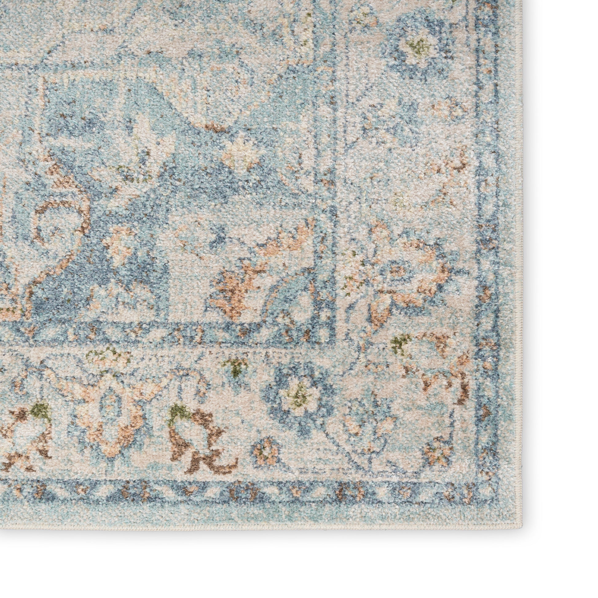 Distressed blue and cream oriental rug corner with floral border, plush pile, ideal for living room decor.