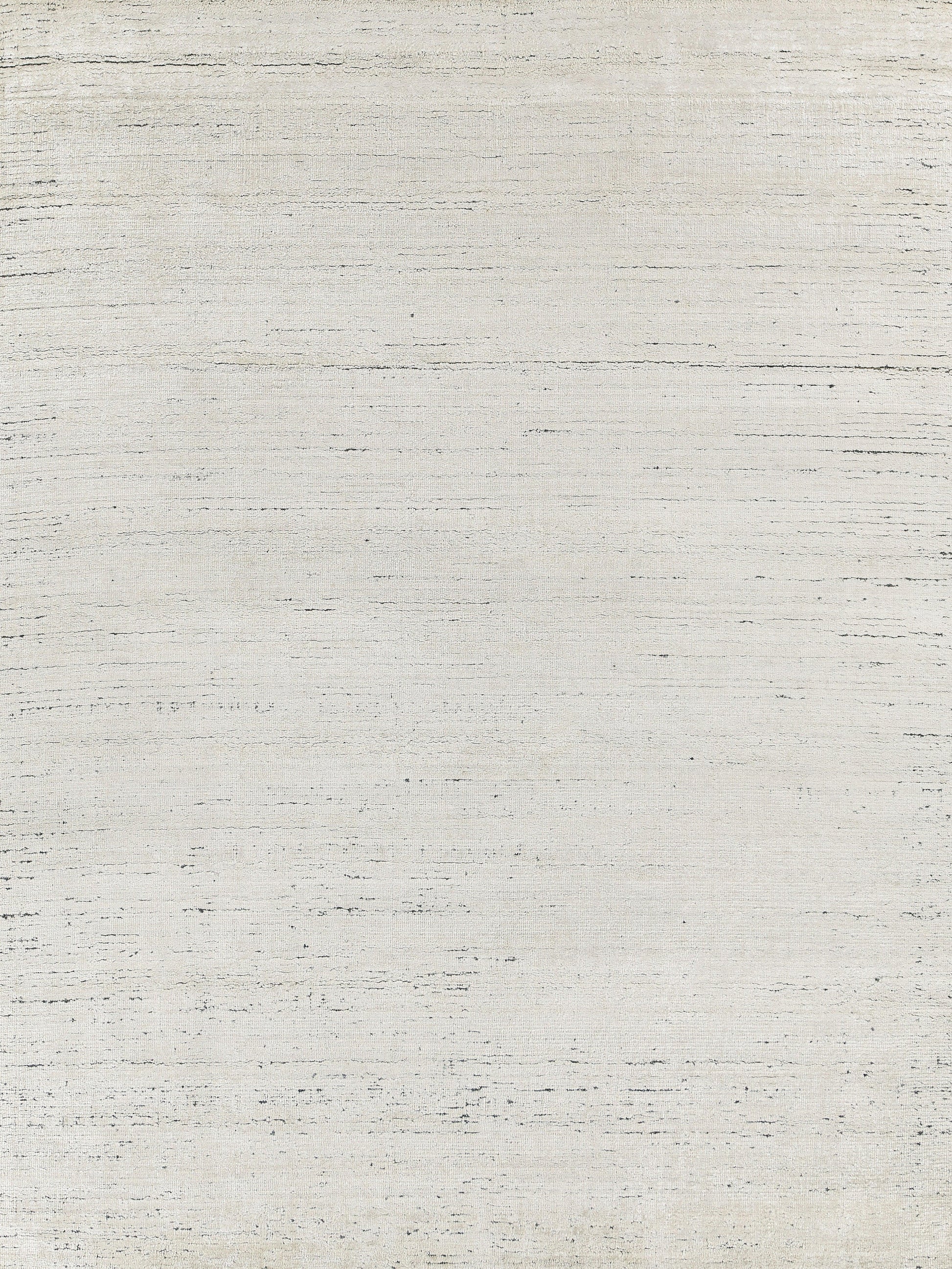 Creamy off-white rug with a subtle woven texture against a rustic backdrop.
