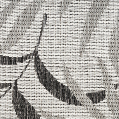 Gray and white woven 6' runner rug with charcoal geometric leaf/chevron motifs in a tight weave.