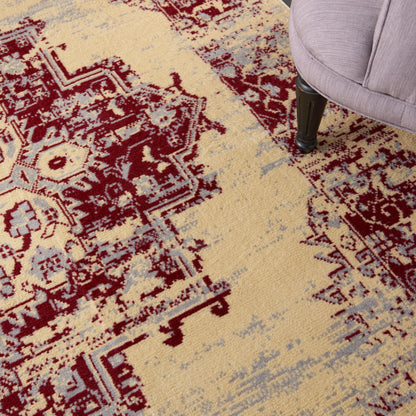 Beige oriental rug with burgundy geometric motifs and light blue accents; dark chair leg visible.
