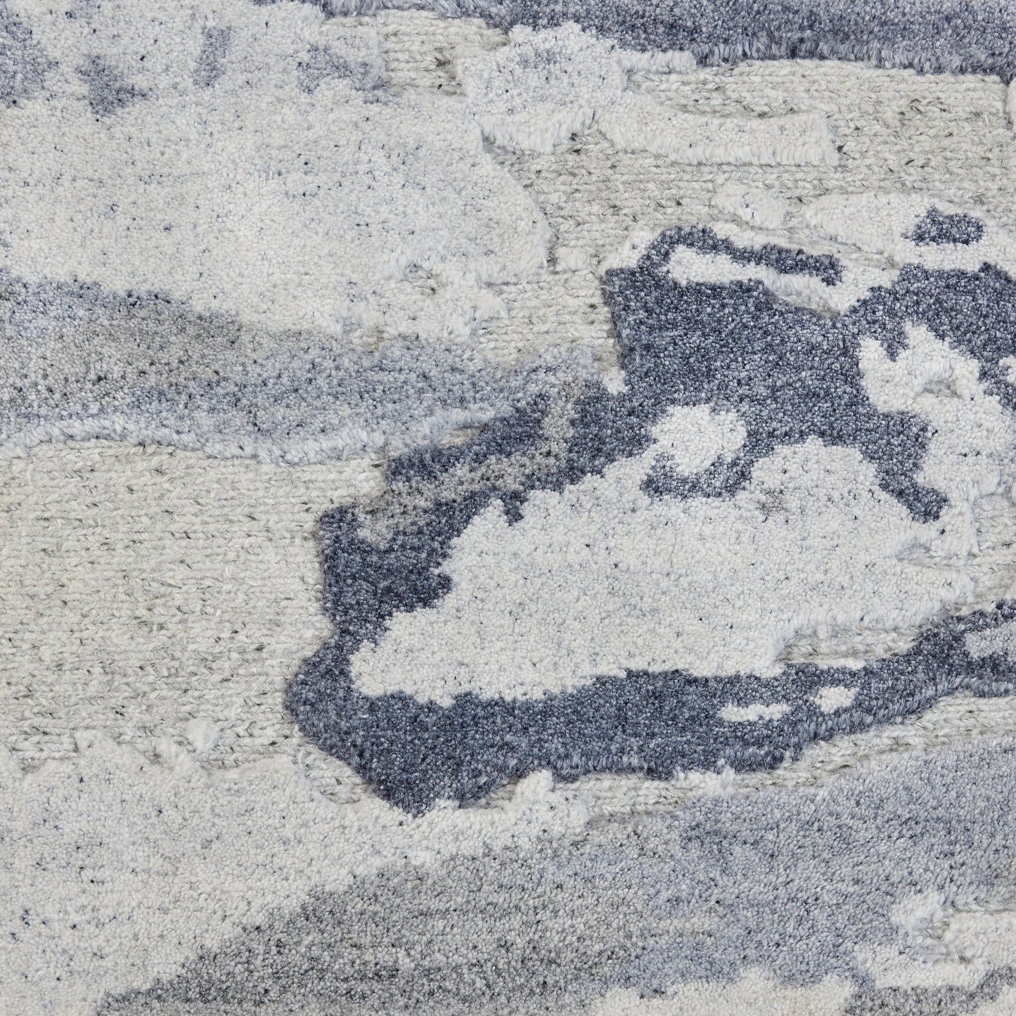 Abstract blue, gray and white plush shag rug with cloud-like pattern and soft high-pile texture.