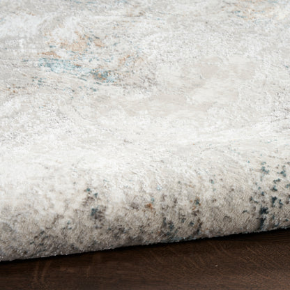 Close-up of a light gray-beige rug edge on a dark wood floor with subtle blue accents.