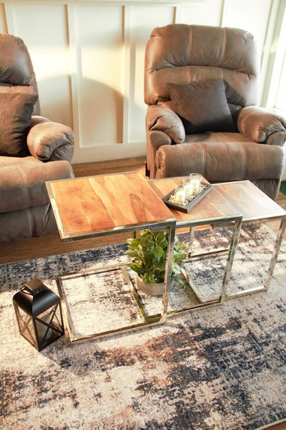 Set of three wood-and-metal C-shaped nesting end tables; in a living room setting with a plant under the tables and a lantern on a rug nearby.