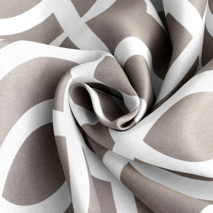 Taupe and white geometric blackout window curtain panel with bold curved trellis shapes, draped to show soft folds and texture.