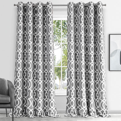 Gray geometric lattice patterned curtains hanging from a silver rod, floor-length in a bright living room.