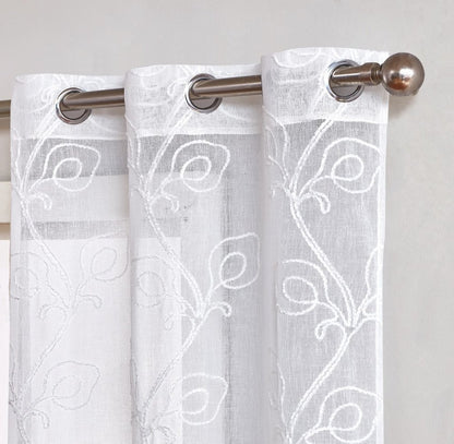Three white sheer curtains with embroidered vine pattern, hung on a metal rod with round finial.