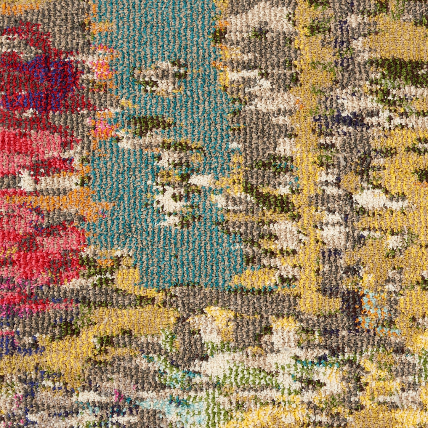 Close-up of a vibrant abstract area rug with teal, yellow, gray, beige and red accents; looped pile texture.