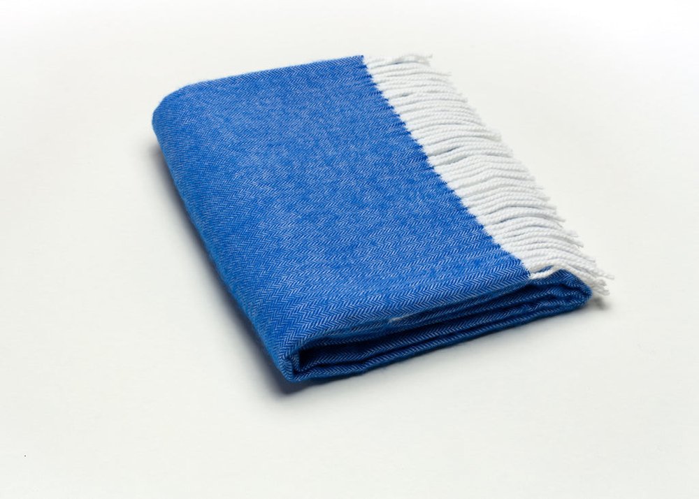 Blue and white woven herringbone plush throw blanket, 50 x 60 inches, folded for couch or bed decor.