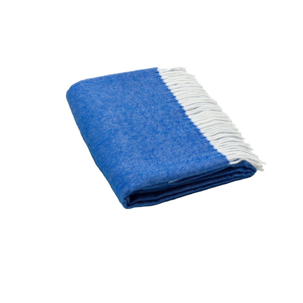 Blue throw blanket with white fringe along edge, folded for display, cozy home decor accessory.