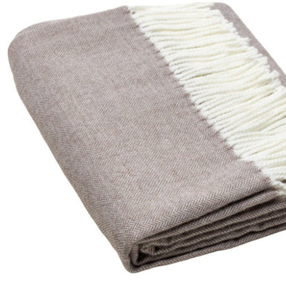 Taupe herringbone throw blanket with white fringe, folded for display