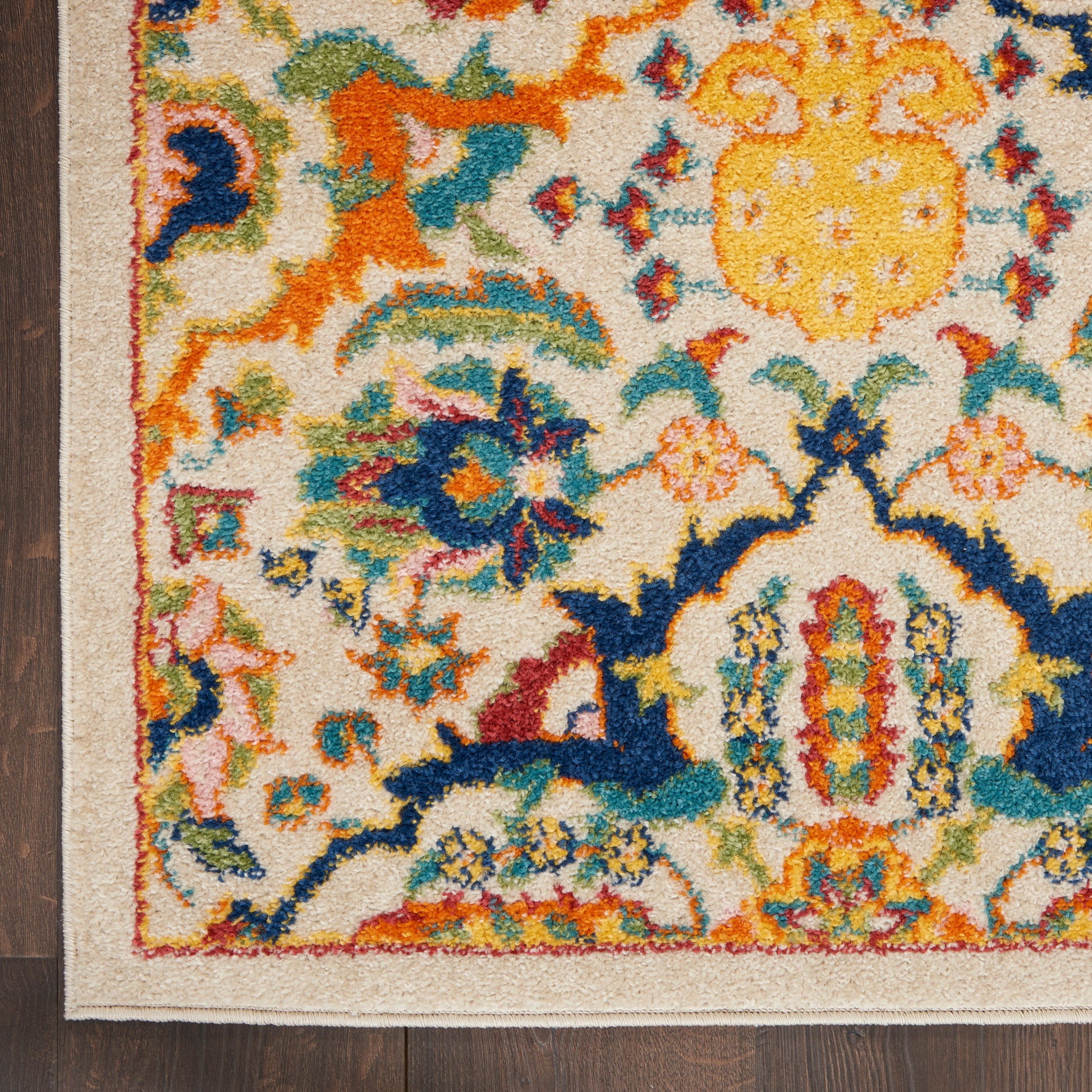 Colorful traditional rug with cream background and floral motifs in yellow, orange, blue, teal and red; beige border.