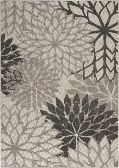Gray-scale rug featuring oversized dahlia-like rosettes in layered petals on beige background