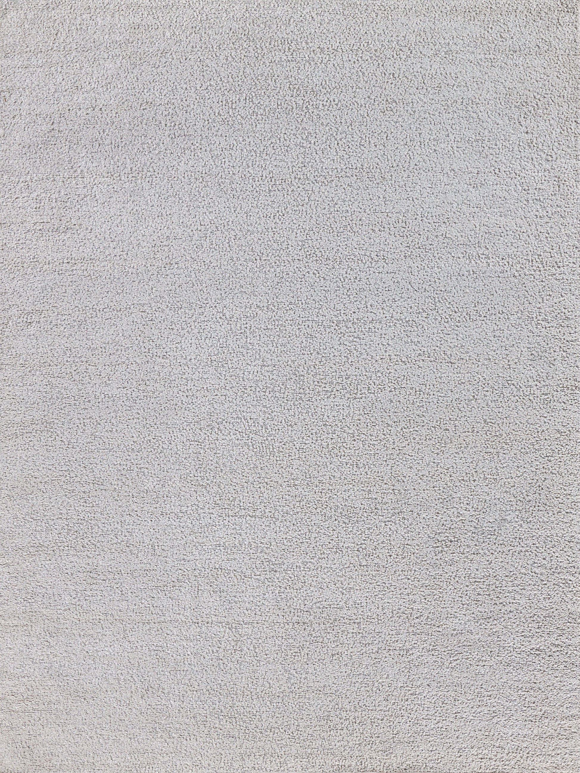 Close-up of light gray rug texture with dense loop pile.