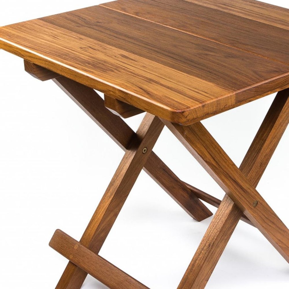 Rustic wooden folding table with warm brown finish; rectangular top and X-frame trestle legs.
