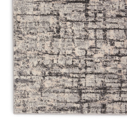 Abstract beige and gray rug with distressed pattern and light bound edge.
