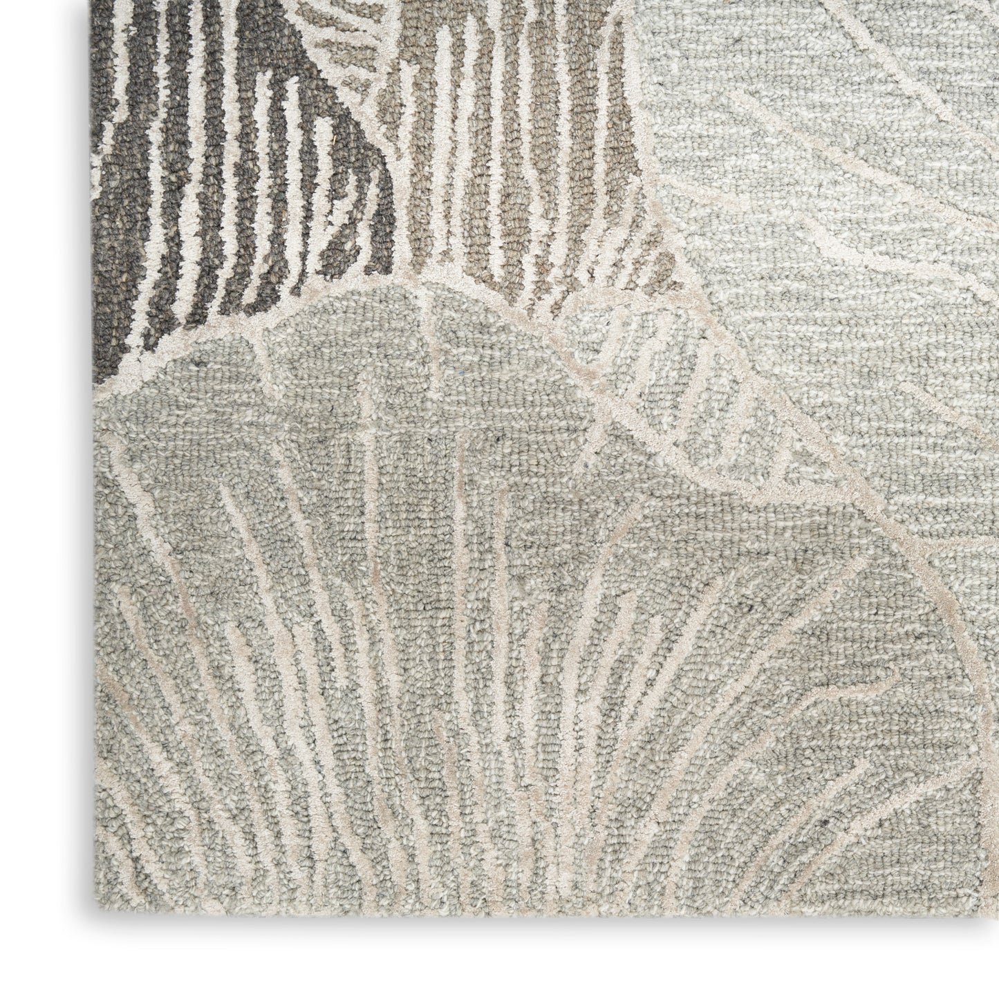 Neutral-toned textured rug with abstract leaf pattern in beige, taupe and ivory; loop-pile texture.