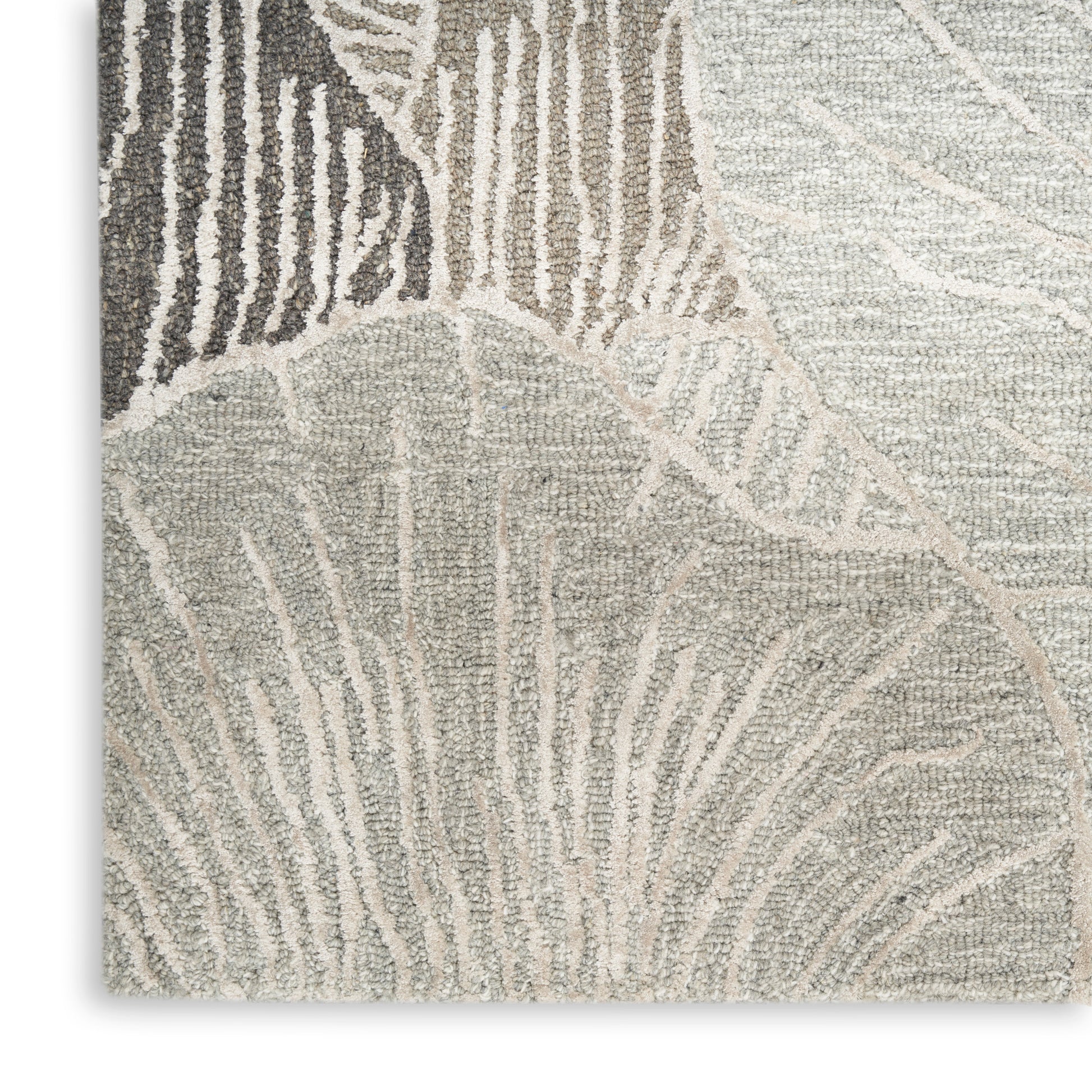 Neutral-toned textured rug with abstract leaf pattern in beige, taupe and ivory; loop-pile texture.