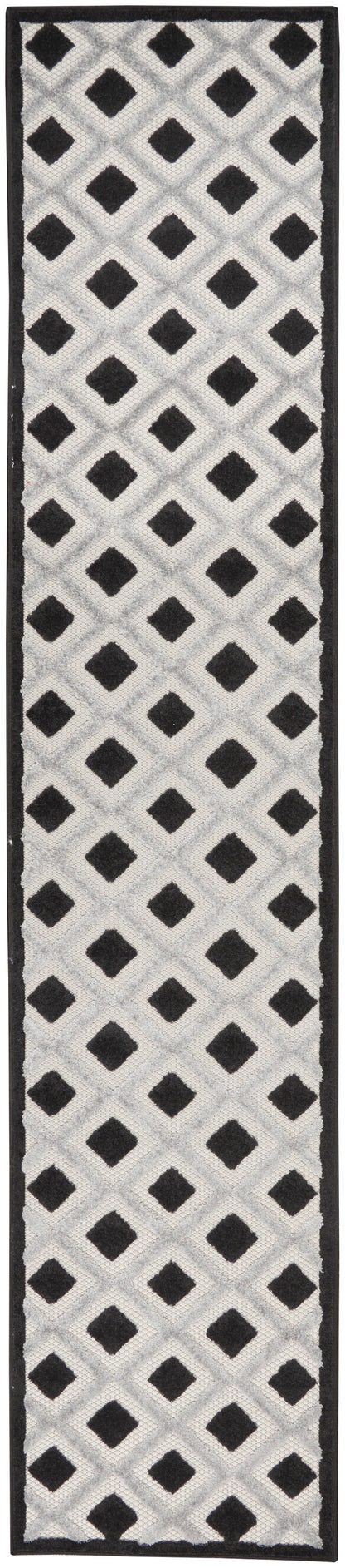 Rectangular tufted rug runner in white-gray lattice with black diamond motifs and black border; geometric hallway rug.