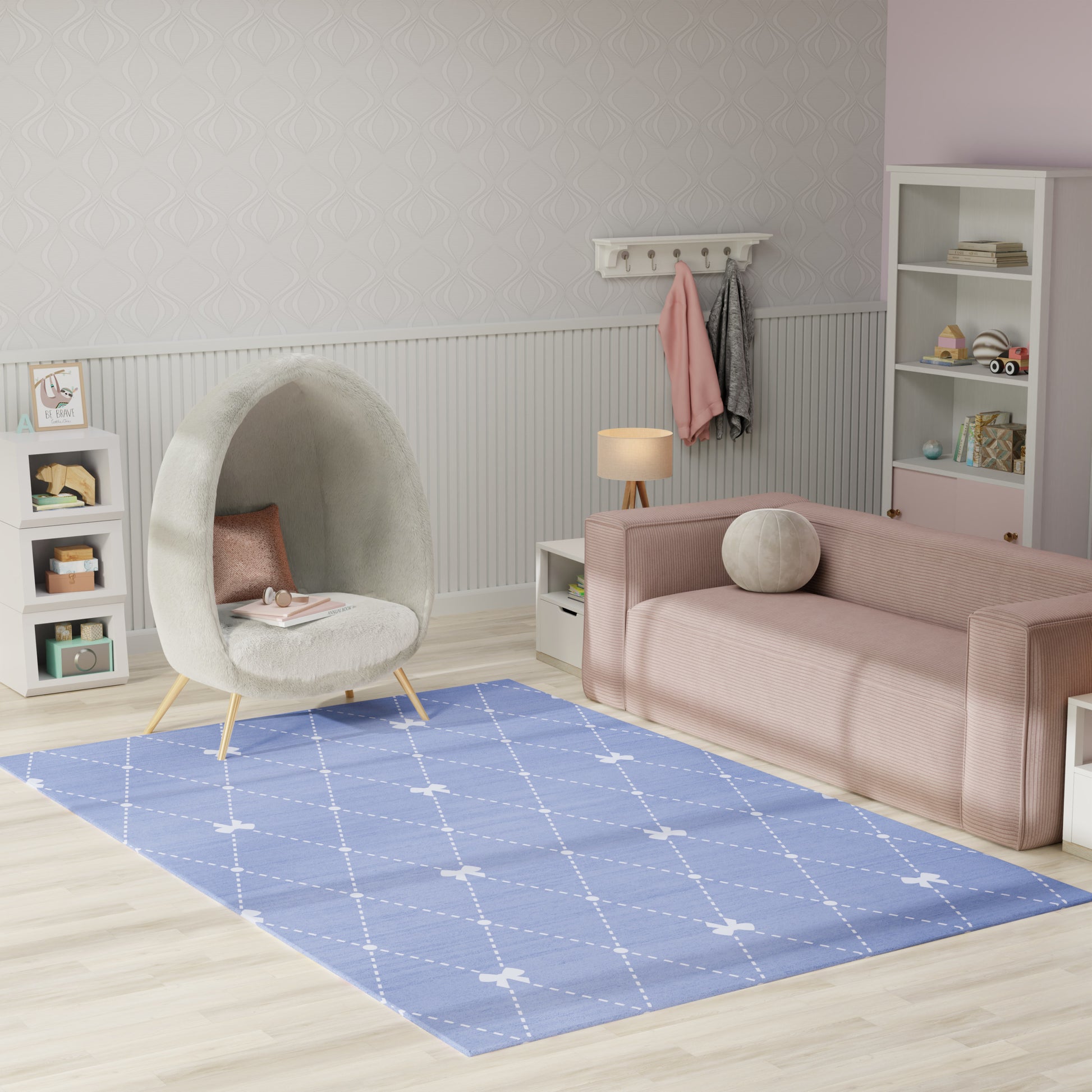 Pastel kids space: pink velvet sofa, grey cocoon chair, blue diamond rug, white shelves, light wood floor.