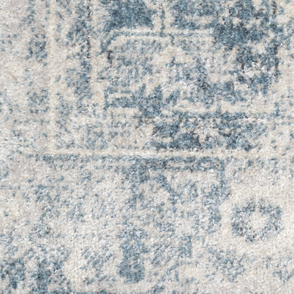 Blue-gray distressed patterned area rug with ivory background and vintage floral motif.