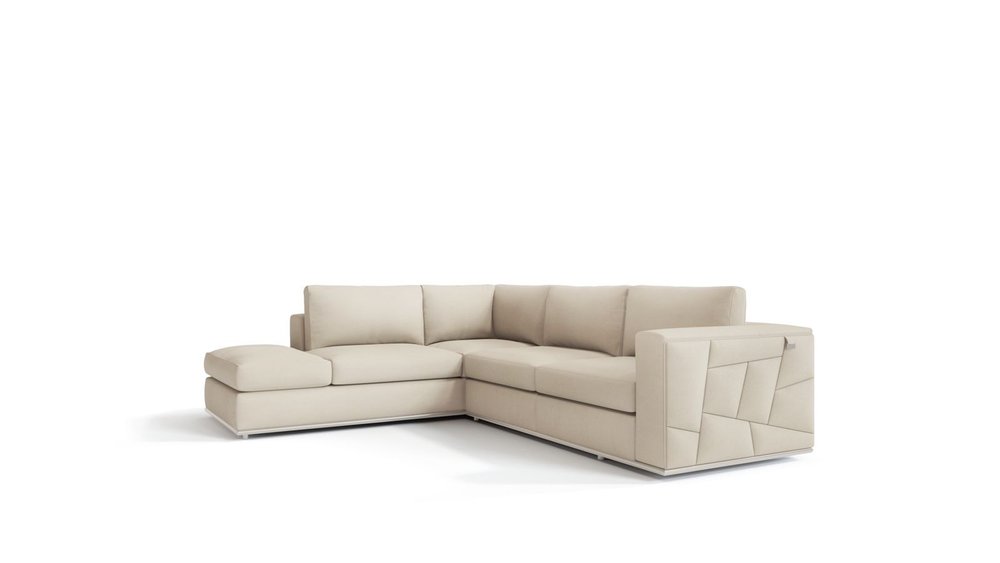 Beige fabric L-shaped sectional sofa with left chaise and low back cushions; geometric stitched arm panels.