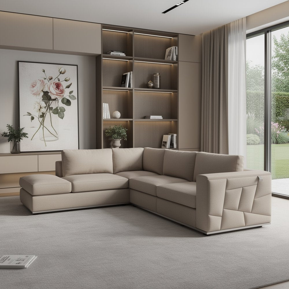 Beige modular sectional sofa with chaise in a modern living room, built-in bookshelf, warm lighting, and large windows.