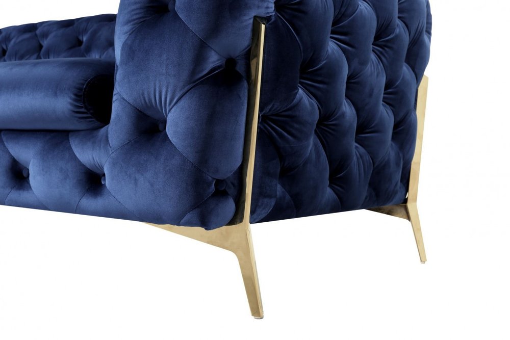 Blue velvet tufted lounge chair with gold accents.