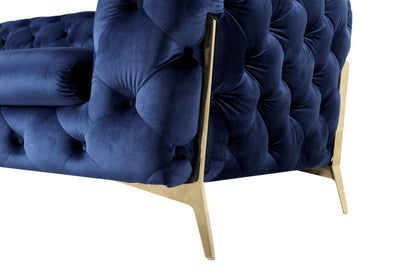 Blue velvet tufted lounge chair with gold accents.