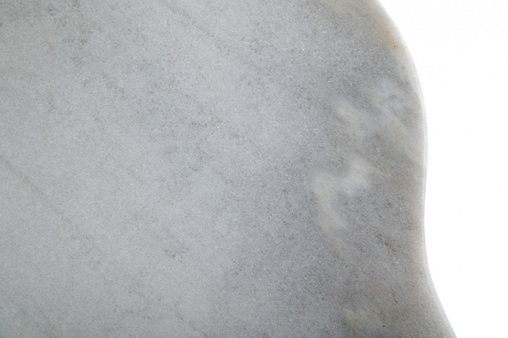 Close-up of light gray marble texture with subtle veining and a rounded edge.