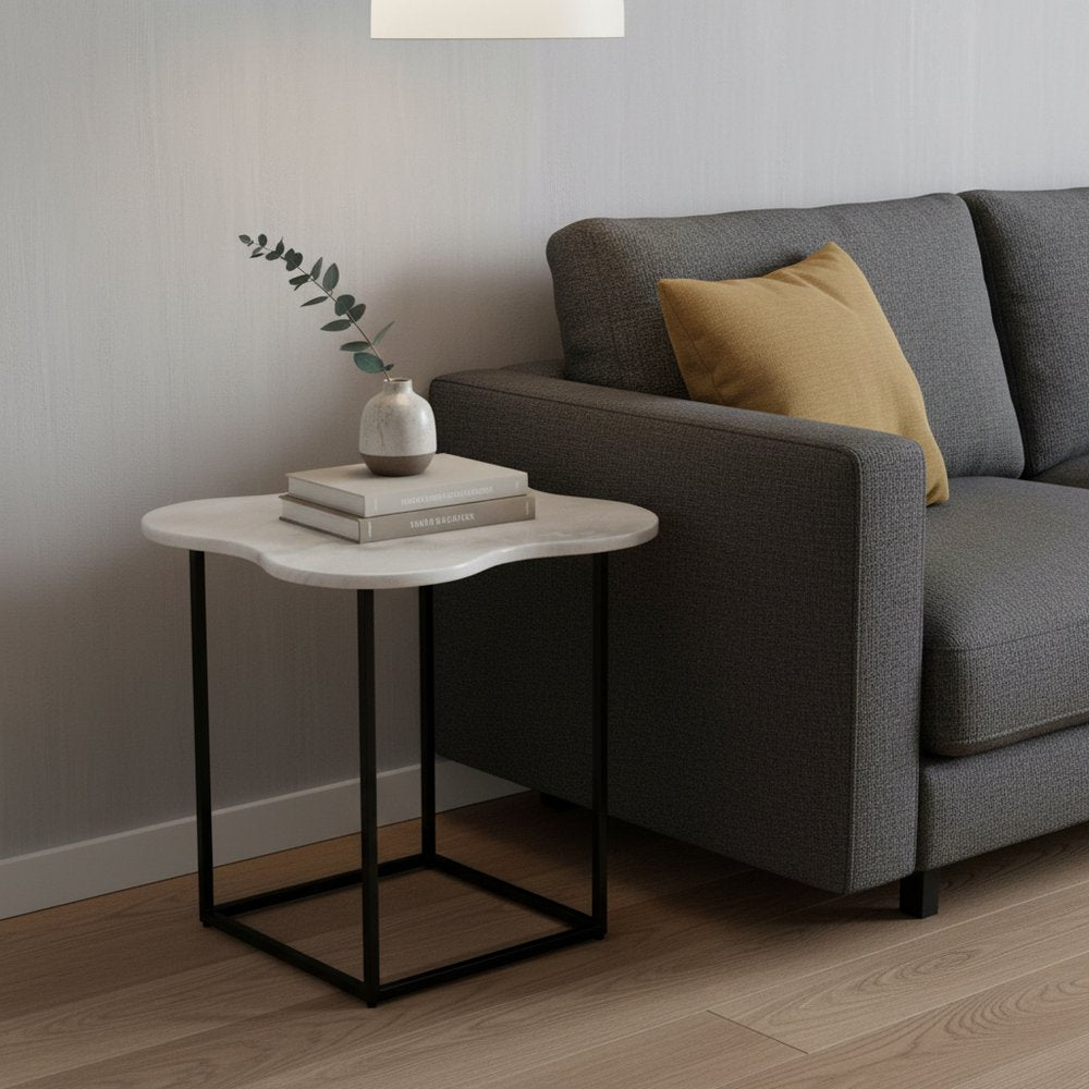 15-inch end table with a black & white marble free-form top on a black metal frame; vase & books on its surface.