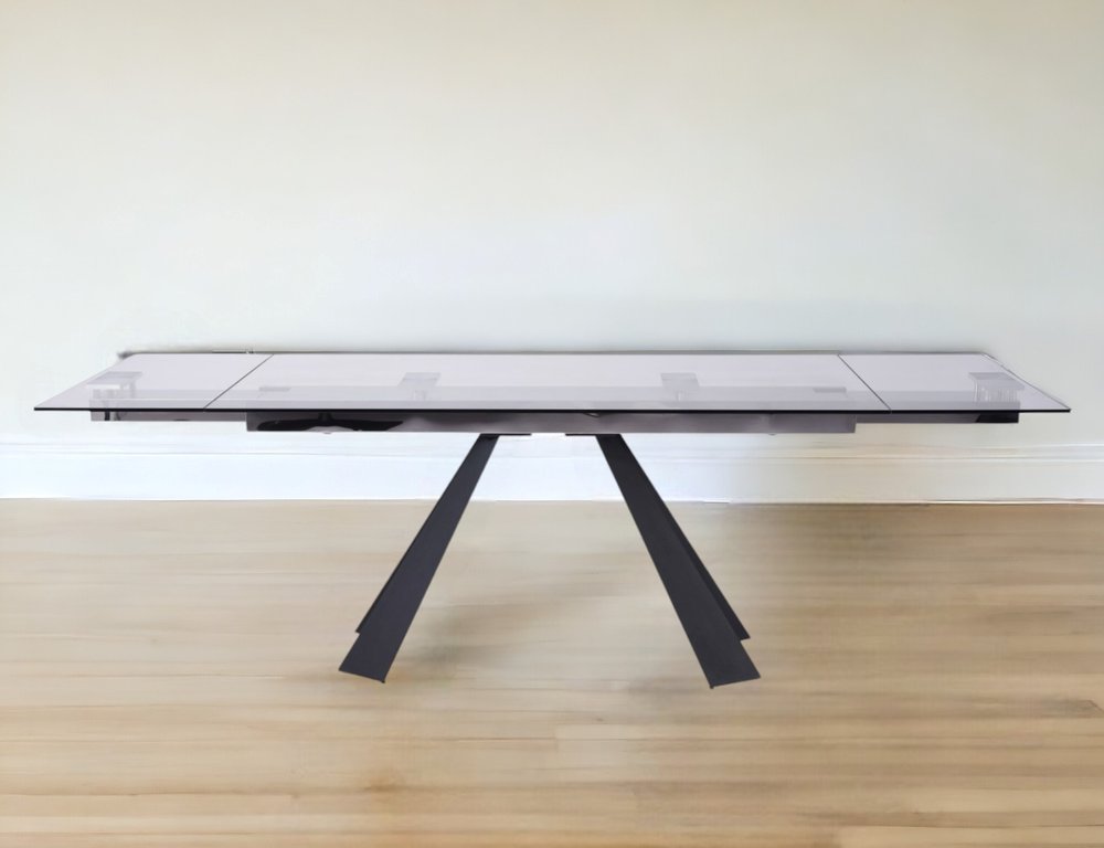 Rectangular smoked glass coffee table with black angled V-shaped metal legs, modern minimalist design.