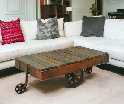 50" Brown and Black Solid Wood and Iron Distressed Wheel Coffee Table