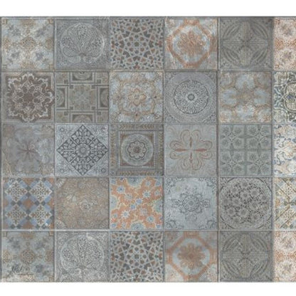 Patchwork ceramic tile sheet of square patterned tiles in muted blue-gray and beige, with floral and geometric motifs.