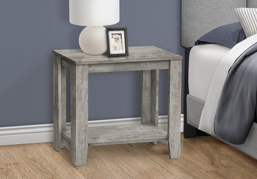 Weathered gray wood nightstand with lower shelf beside bed; lamp and framed photo on top.