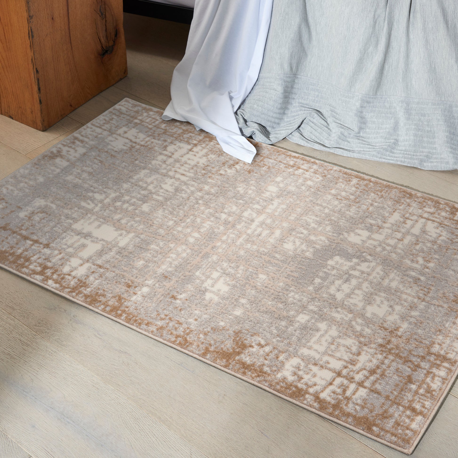 Rectangular beige-gray area rug with a distressed geometric pattern and taupe border; soft low-pile, perfect for living room or bedroom.