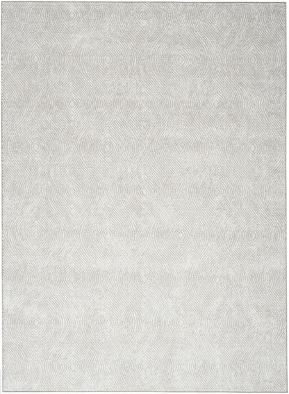Light grey textured rug with faint circular woven pattern, soft pile, modern floor decor.