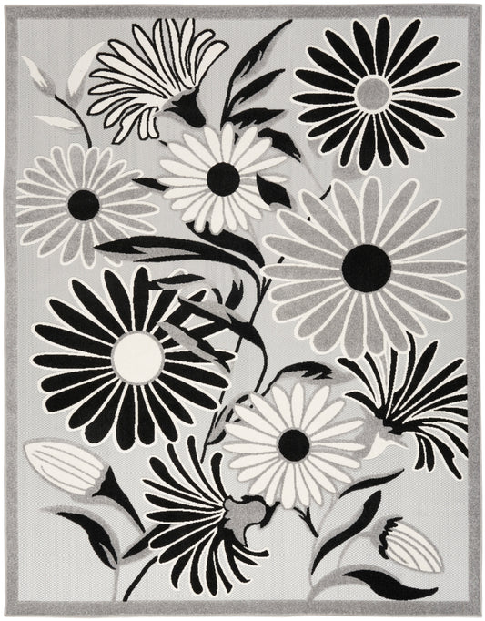 Grey floral area rug with large black, white and gray daisy blooms and a light border.